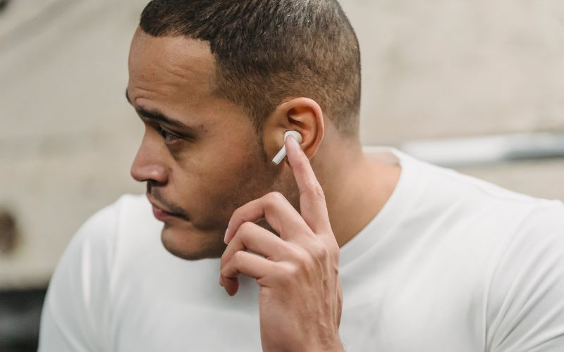 Man adjusting secure workout earbuds that won’t fall off during exercise